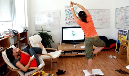 This customer practices a yoga pose using Wii Fit.  Researchers say the gaming system could provide a new <br> kind of physical therapy for patients suffering from neurodegenerative diseases. [Credit: enfad, flickr.com].