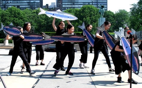 Participants dance with cardboard anchovies on the United Nations plaza at "Fishes Feed Us," the 2007
event designed by Cynthia Pannucci [Credit: Marcia Rudy].