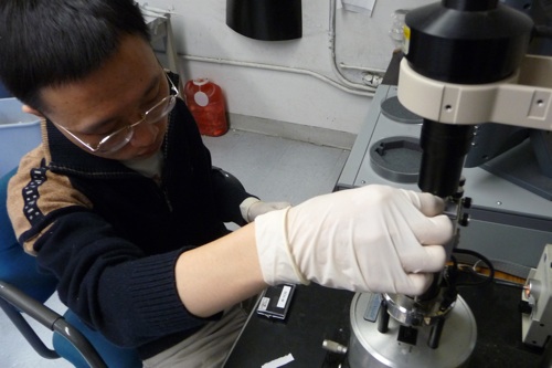 Researcher Hongzhou Gu places a DNA sample in the atomic force microscope for inspection. [Credit: Robert Goodier] Below left, An image captured by the atomic force microscope of the DNA origami to hold a robotic arm. [Credit: Hongzhou Gu]