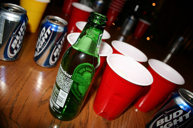 Beer cans and red solo cups on a wooden table