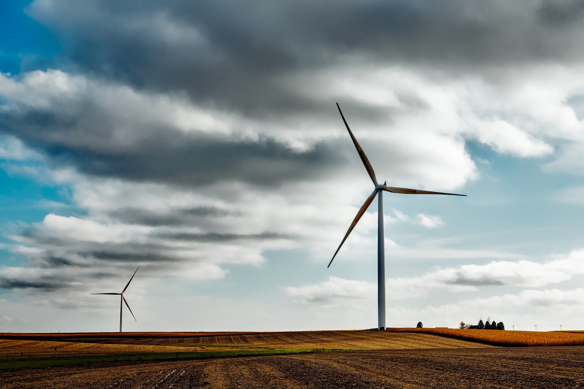 Two windmills stand in a field