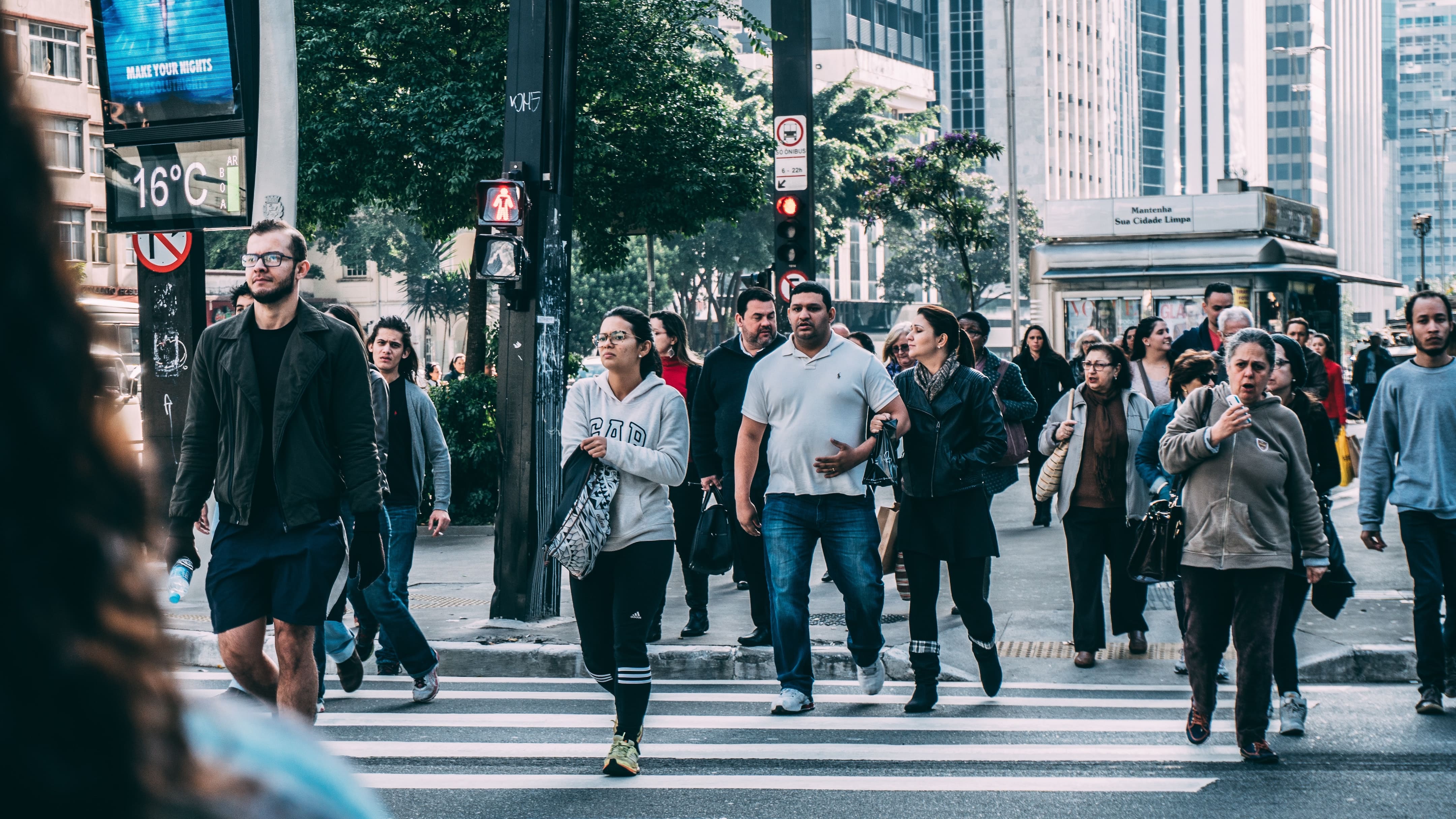 A crowd of people is crossing the street