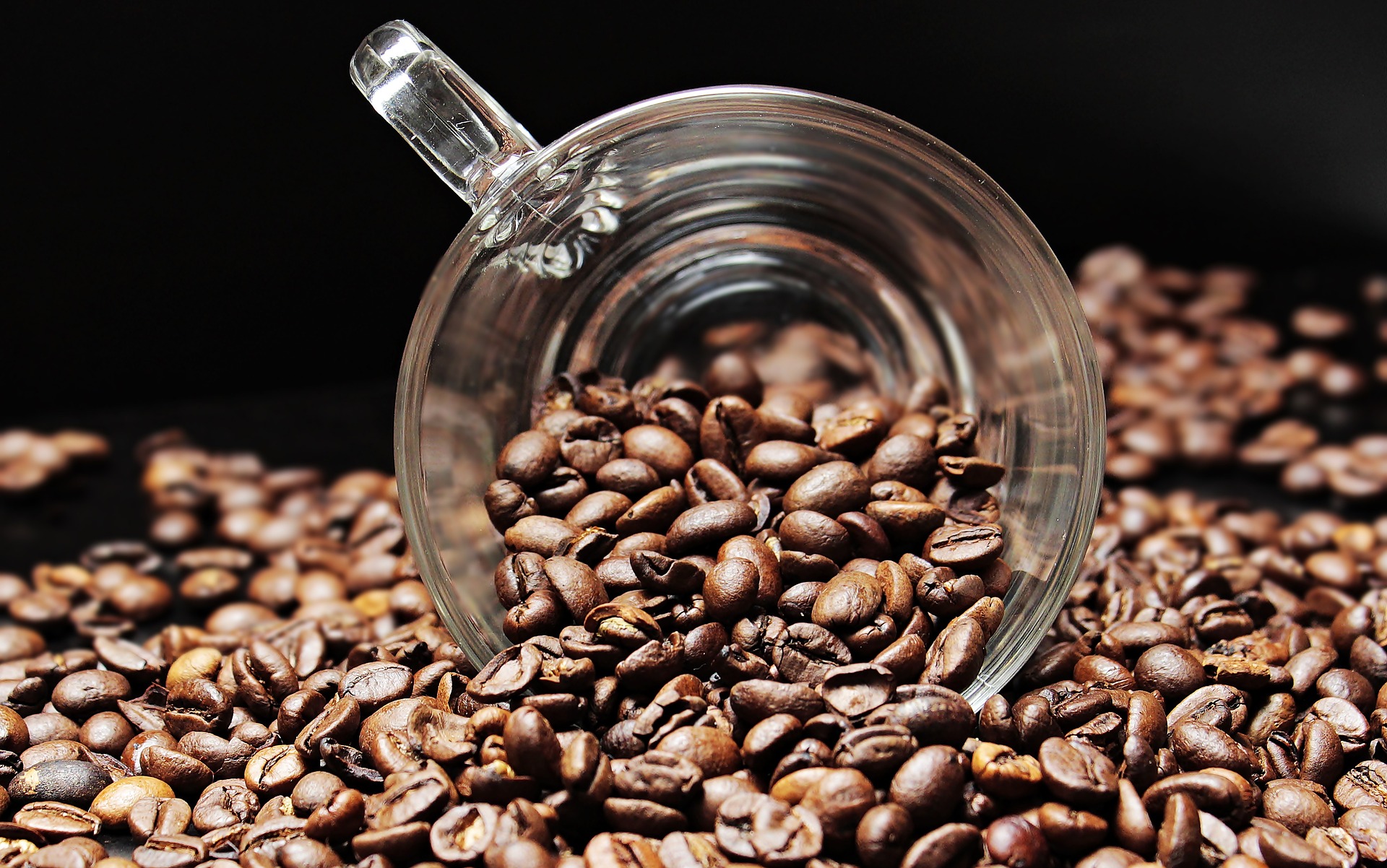 cup scooping coffee beans