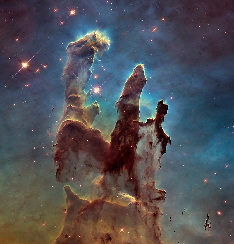 Image of the Eagle Nebula, which is a cloud of gas and dust again a colorful cosmic background. This image is often referred to "The Pillars of Creation" because it looks like pillars and could be similar to what early galaxies looked like.