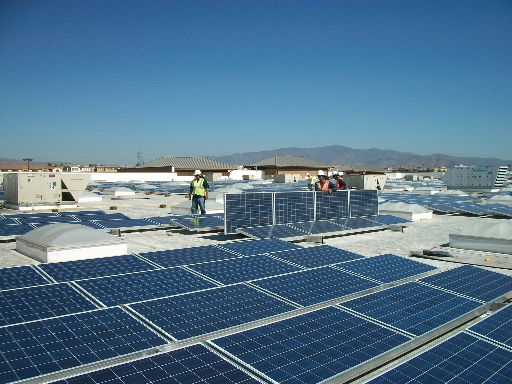 Workers installing solar panels on the roof of Walmart in Chula Vista, Calif.