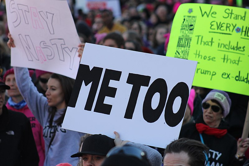 Protestors march with #MeToo poster board at Women's March in Baltimore, 2018