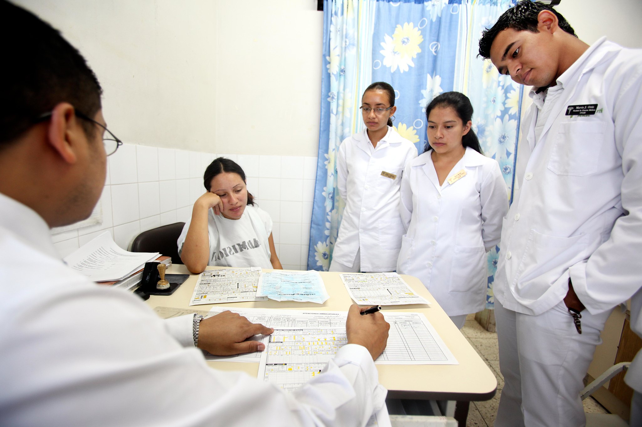 Medical professionals gather around a set of documents