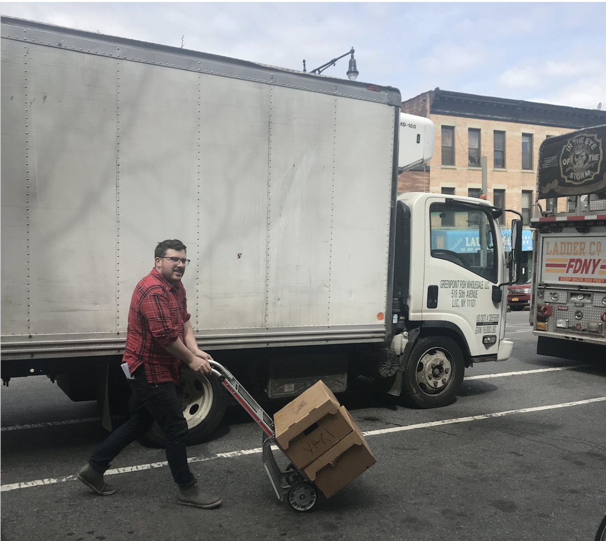 man pushing dolly in front of delivery truck