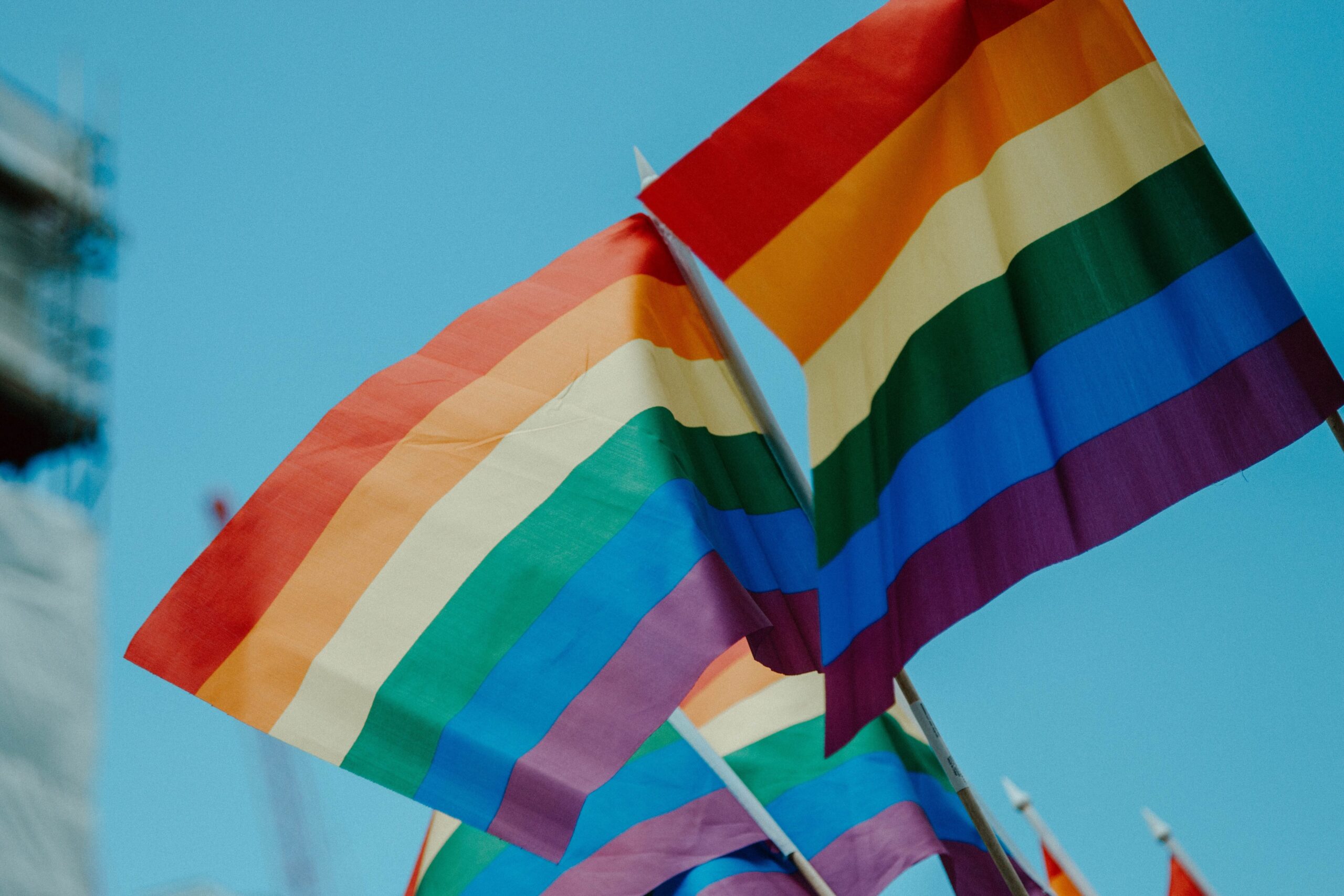 Photo of lgbt rainbow flags against a blue sky