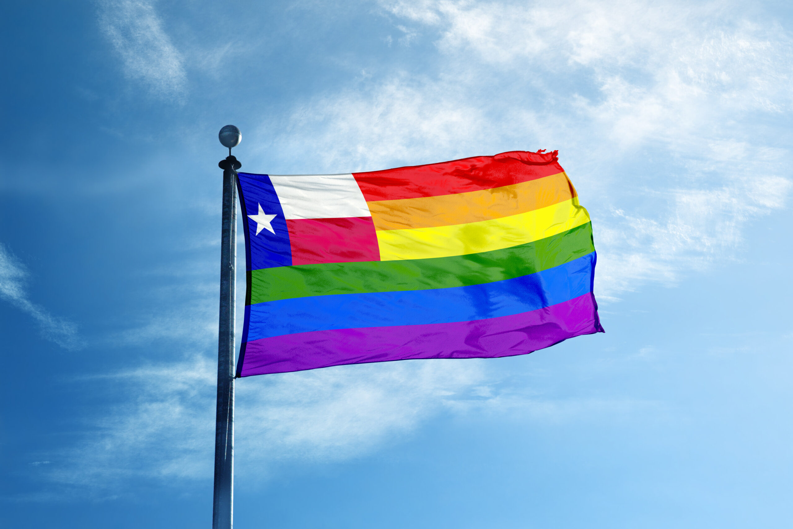 A Texas Pride flag and a clear blue sky.