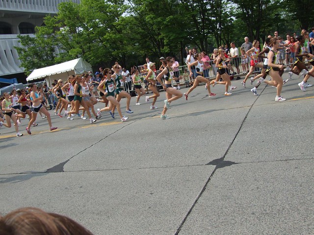 About 30 people running together in a road race.