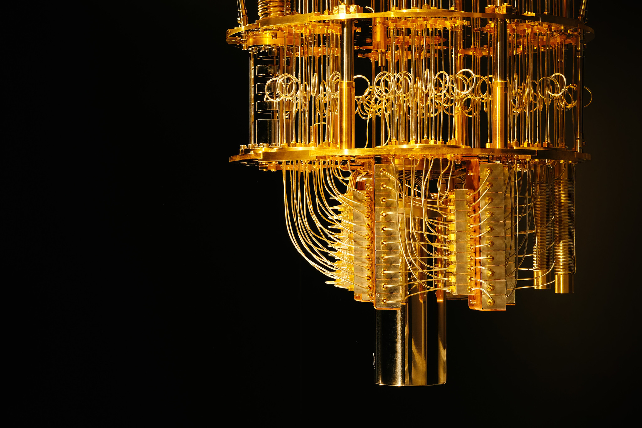 A photograph of a golden-colored quantum computer against a black background.