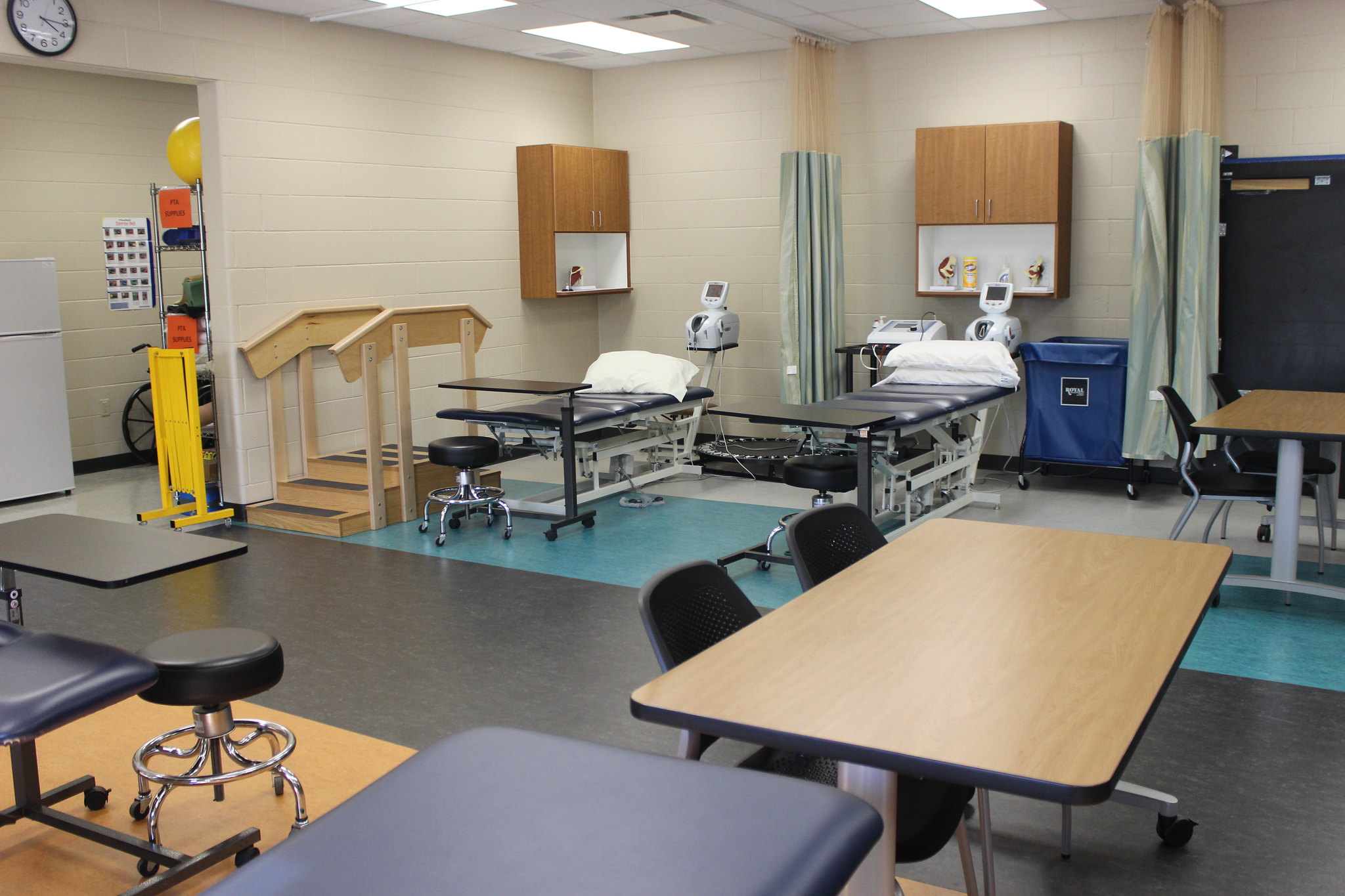 A room filled with tables, monitors and equipment to facilitate physical therapy for patients