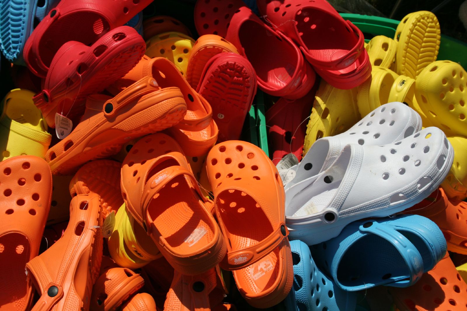 A pile of multicolored classic Crocs shoes