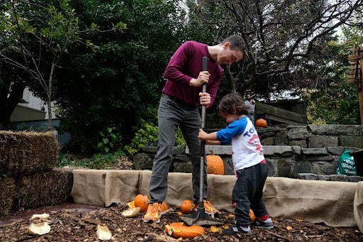father and son smashing a pumpkin with pumpkin tenderizer