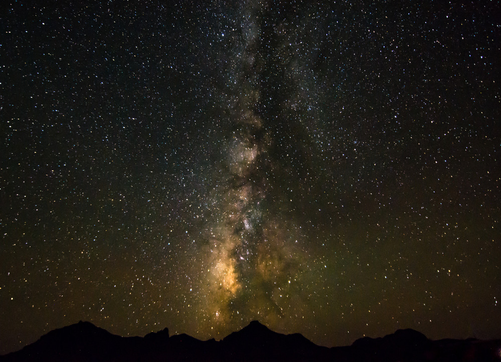 The stars and Milky Way are visible above a mountain range in Big Bend National Park.