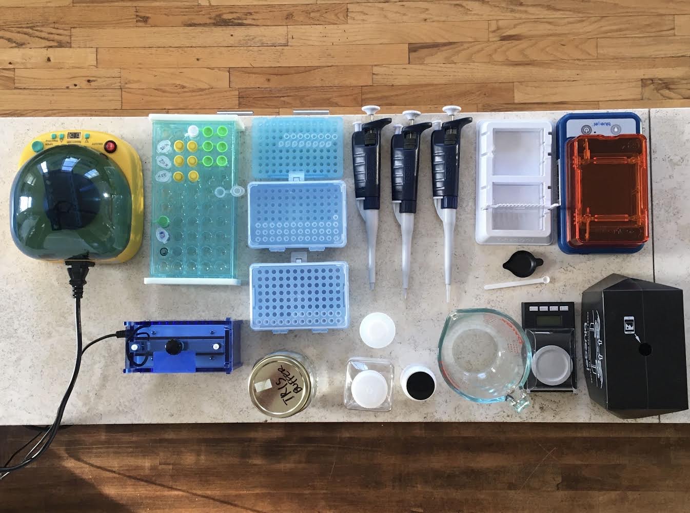 A photograph of the materials Jakob uses to sequence mushroom DNA, including a small centrifuge, pipettes, and various containers for storing samples.
