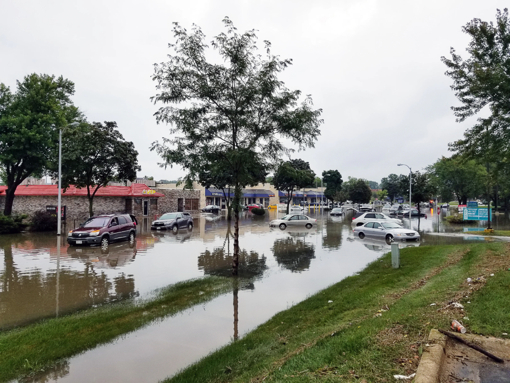 Several cars sit on a flooded street