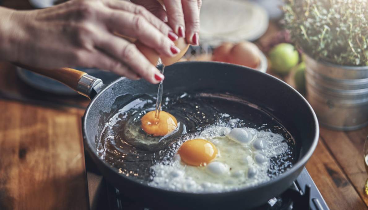 two eggs sizzle in a frying pan