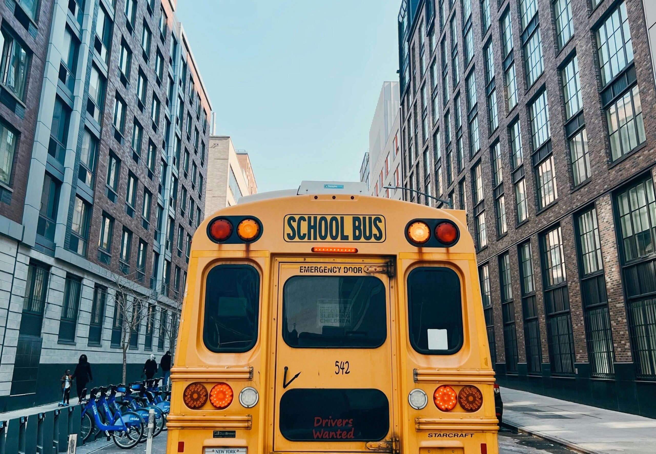 A school bus drives along a New York City street