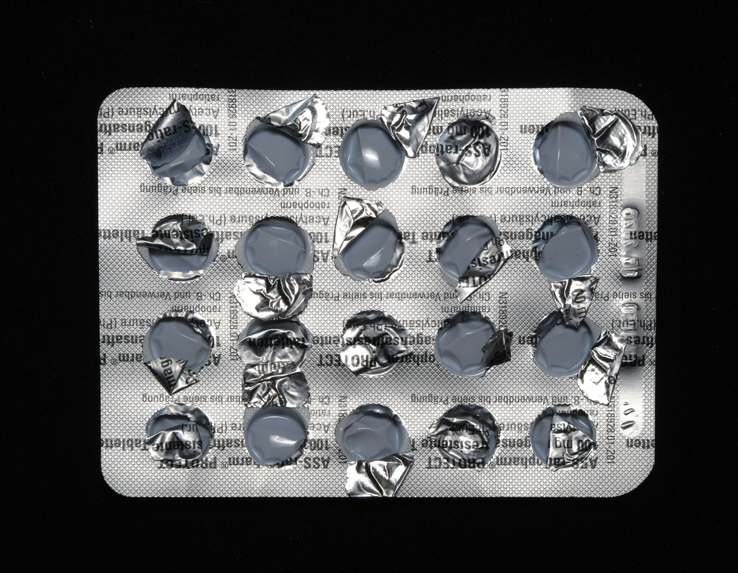 An empty blister pack of pills against a black background